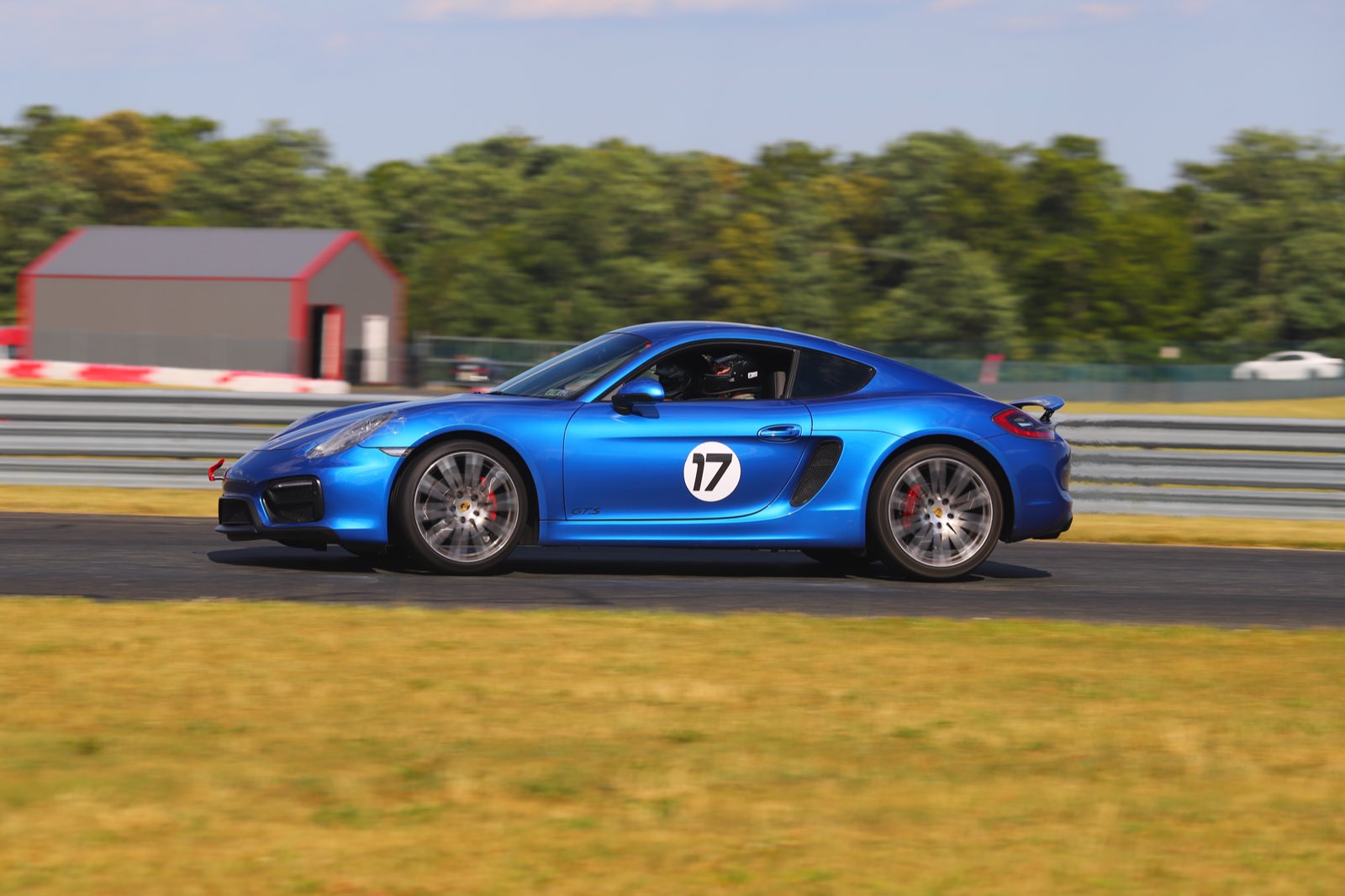 The Cayman GTS at full stretch past the red barn at NJMP Lightning
