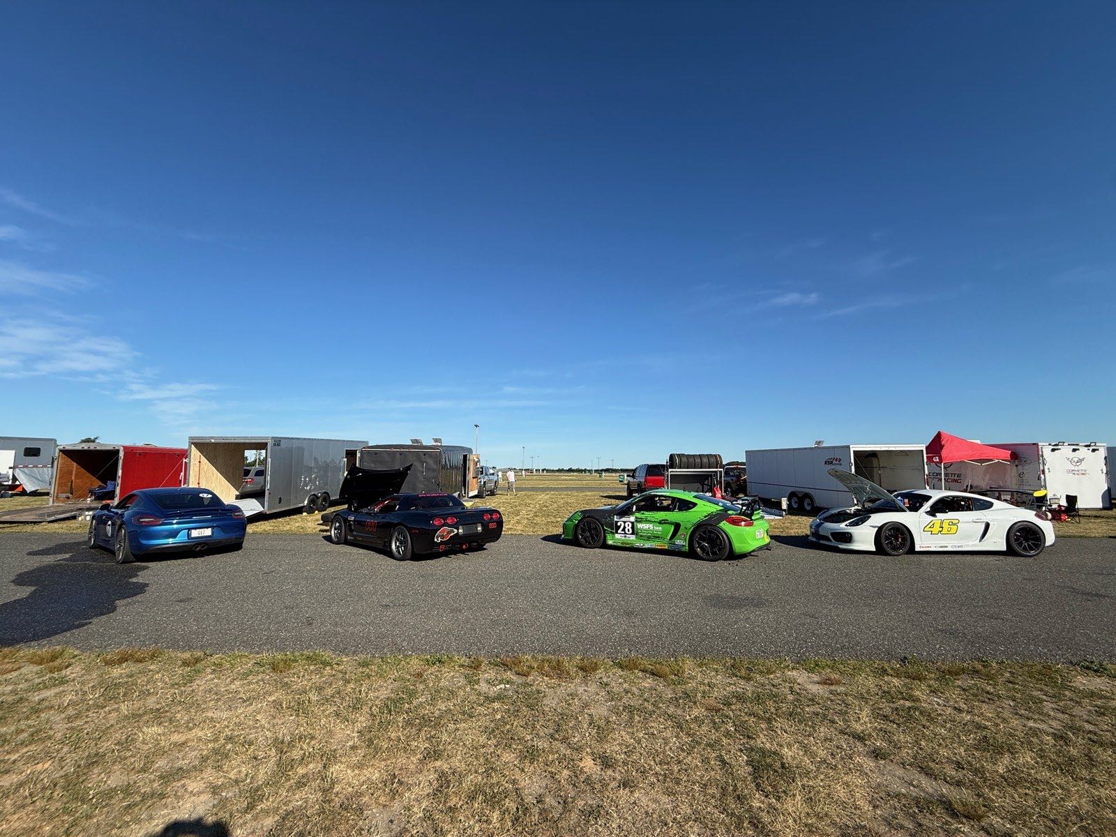 Morning paddock lineup — the Cayman GTS alongside a Corvette and two Cayman race cars